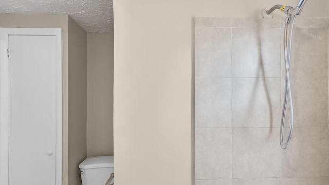 bathroom with toilet and a textured ceiling