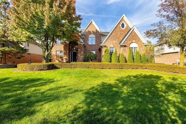 traditional-style house with a front lawn and brick siding