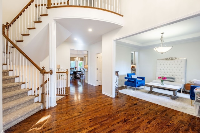 foyer featuring stairs, a high ceiling, wood finished floors, and baseboards