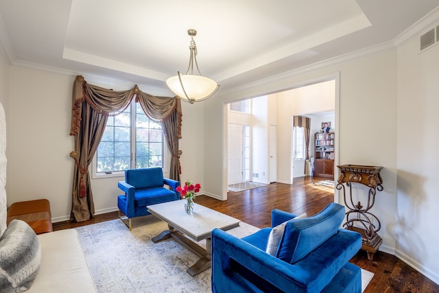 living area featuring baseboards, a raised ceiling, and wood finished floors