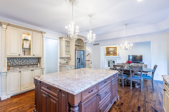 kitchen with cream cabinets, open shelves, dark wood-type flooring, and stainless steel fridge with ice dispenser