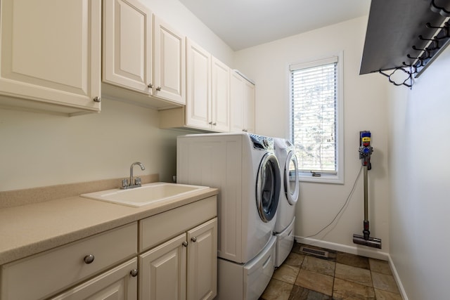 laundry area with cabinet space, visible vents, baseboards, washer and dryer, and a sink