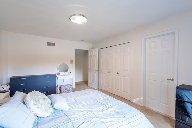 bedroom with a closet, light colored carpet, visible vents, and baseboards