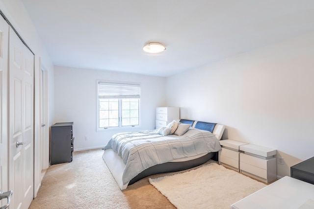 bedroom featuring light carpet and baseboards