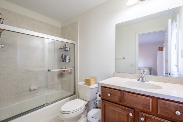 full bathroom featuring toilet, enclosed tub / shower combo, and vanity