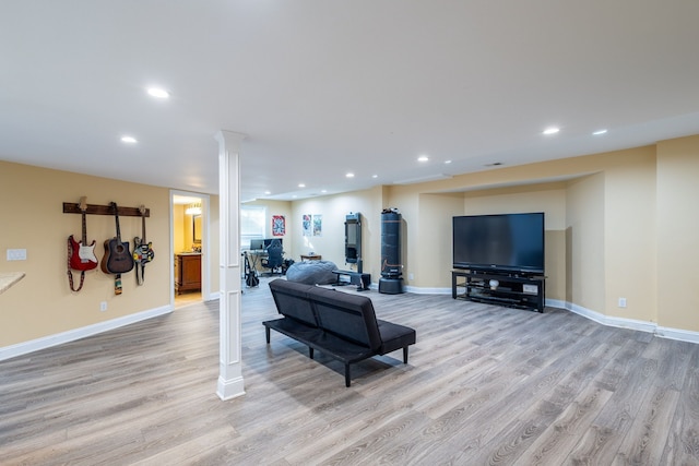 living room with ornate columns, light wood-style flooring, baseboards, and recessed lighting