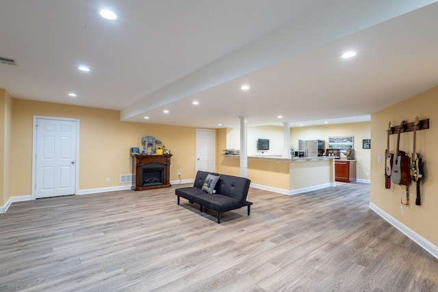 sitting room featuring baseboards, light wood-style floors, a fireplace, and recessed lighting