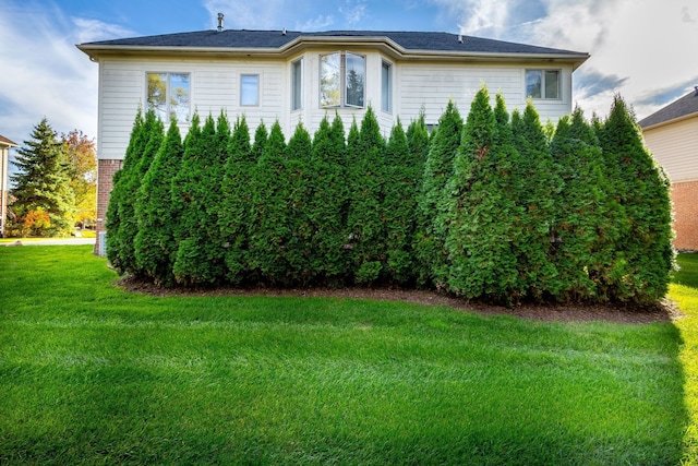 view of property exterior with a lawn and brick siding