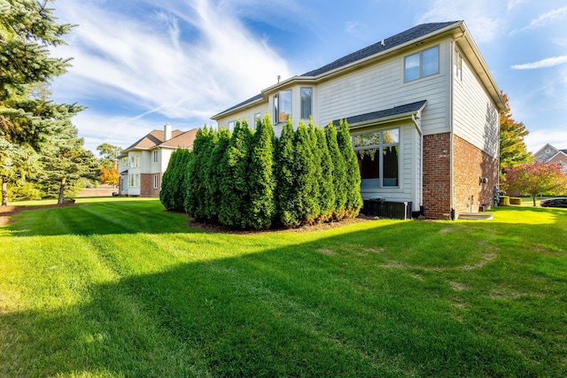 back of property featuring brick siding and a lawn