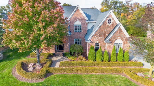 view of front of property featuring a front yard and brick siding