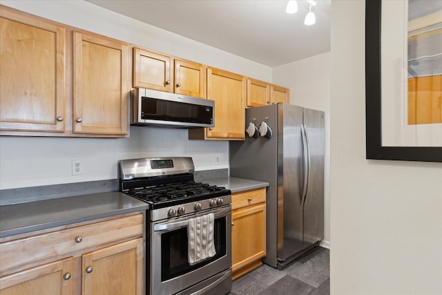 kitchen featuring stainless steel appliances, dark countertops, and light brown cabinets