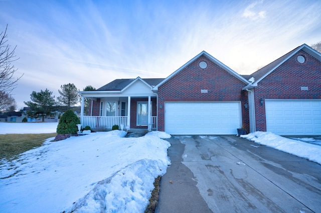 ranch-style house with a garage, covered porch, driveway, and brick siding