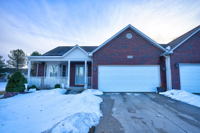 ranch-style home with covered porch, driveway, brick siding, and an attached garage