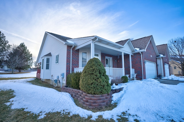 view of front of house with covered porch, brick siding, and an attached garage