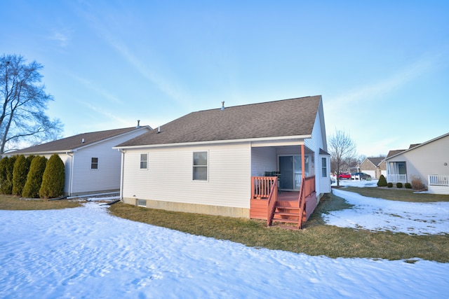 snow covered house featuring a shingled roof