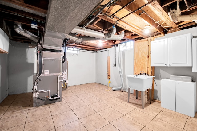 below grade area featuring heating unit, water heater, and light tile patterned flooring