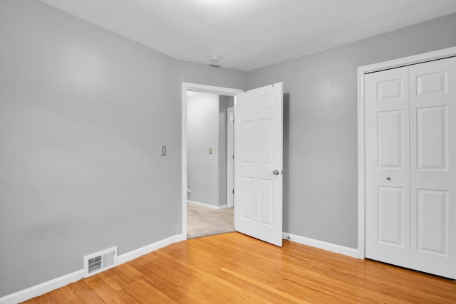 unfurnished bedroom featuring light wood-type flooring, visible vents, and baseboards