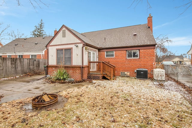 back of house with a patio area, a fenced backyard, a chimney, and brick siding