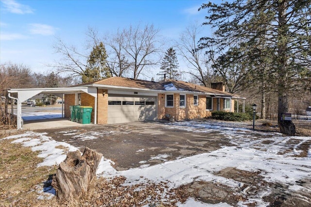 exterior space featuring a garage, brick siding, driveway, and a carport