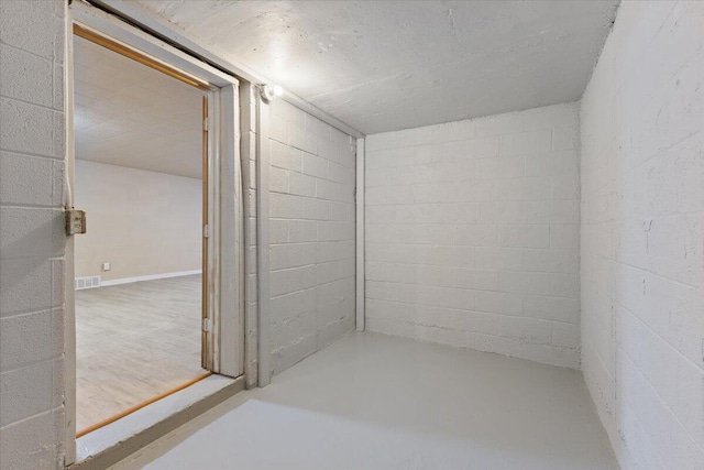 interior space with concrete block wall and visible vents