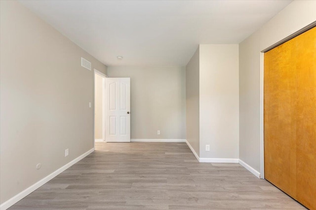 empty room with visible vents, baseboards, and wood finished floors