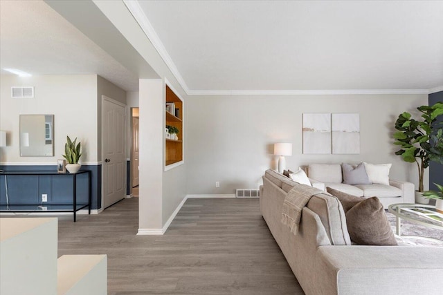 living area featuring ornamental molding, visible vents, and wood finished floors