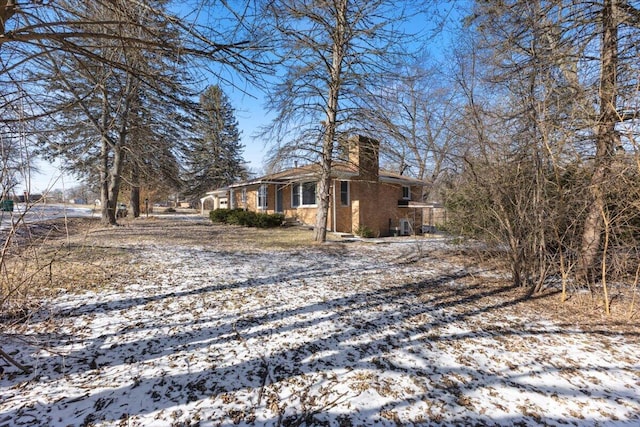 view of snow covered exterior with a chimney