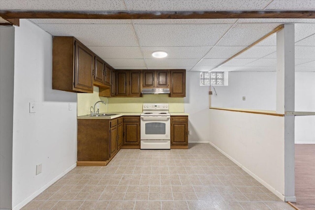 kitchen with white electric range oven, light countertops, a sink, under cabinet range hood, and baseboards