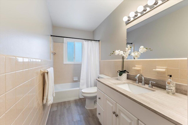 bathroom featuring toilet, vanity, tile walls, and wood finished floors