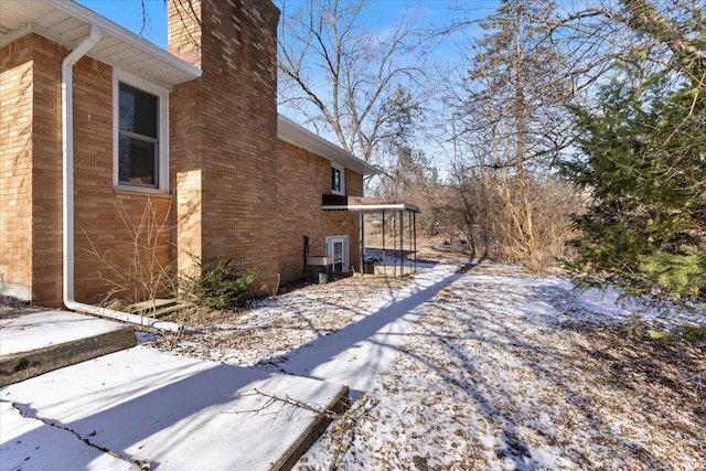 view of side of property featuring brick siding and a chimney