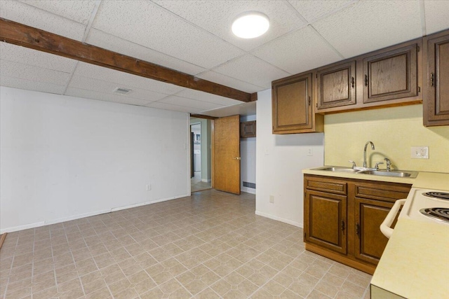 kitchen featuring a drop ceiling, a sink, visible vents, baseboards, and light countertops