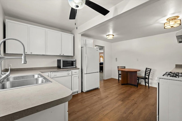 kitchen with dark wood finished floors, a ceiling fan, white cabinetry, a sink, and white appliances