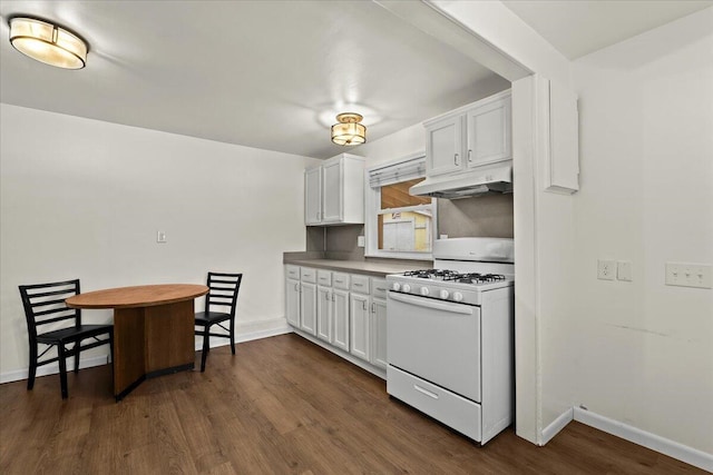 kitchen with under cabinet range hood, white gas range, white cabinets, and dark wood-type flooring