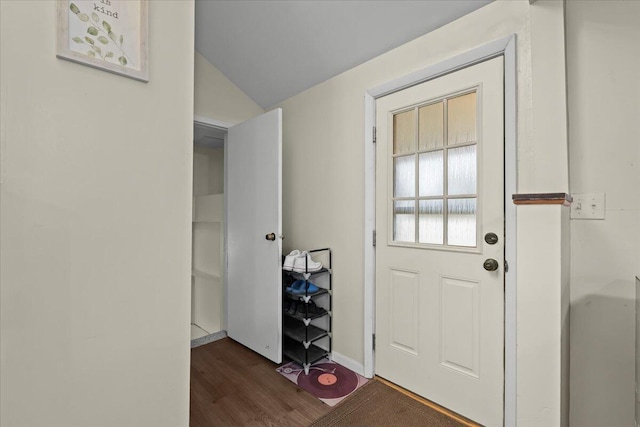 entryway featuring lofted ceiling, dark wood-type flooring, and baseboards