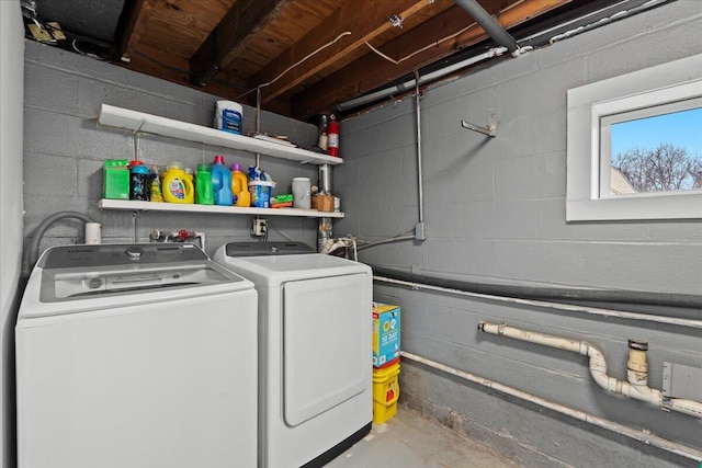 laundry room featuring laundry area, washer and clothes dryer, and concrete block wall