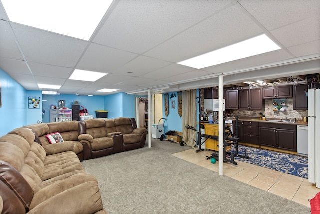 living room featuring light tile patterned floors, a drop ceiling, and light colored carpet