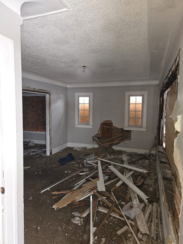 interior space with a textured ceiling and baseboards