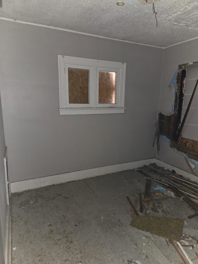 unfurnished room featuring baseboards and a textured ceiling