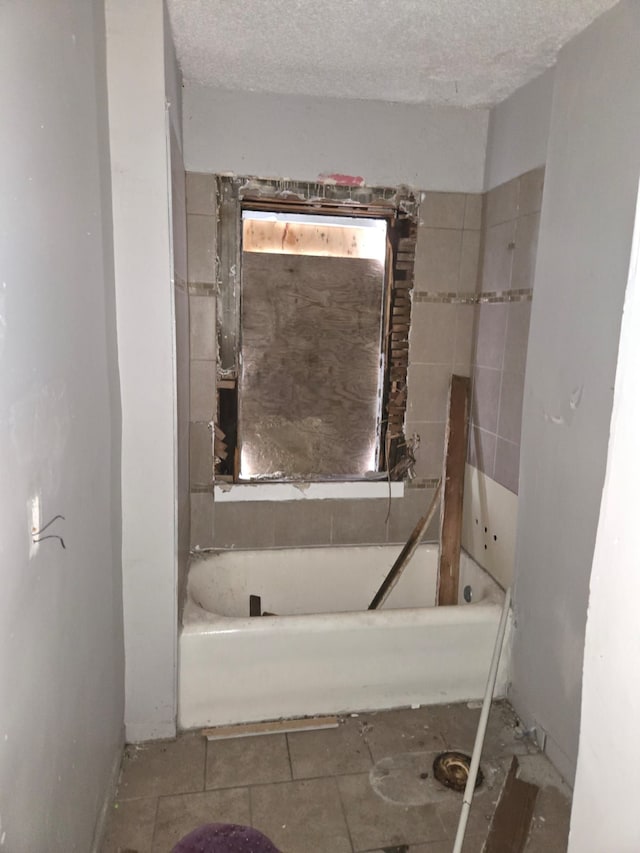 full bath featuring a textured ceiling and a bath