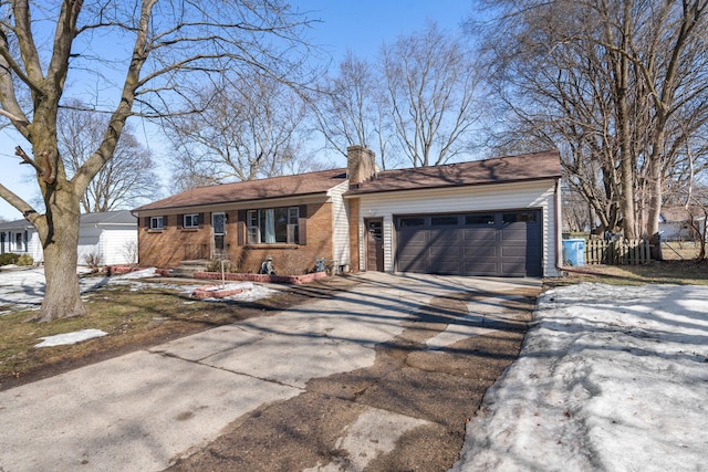 ranch-style home featuring a garage, concrete driveway, a chimney, fence, and brick siding