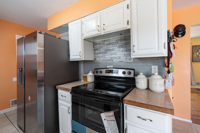 kitchen with light tile patterned floors, stainless steel appliances, visible vents, and white cabinetry