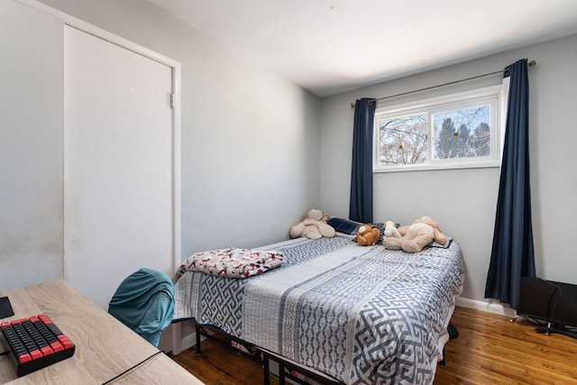 bedroom with baseboards and wood finished floors