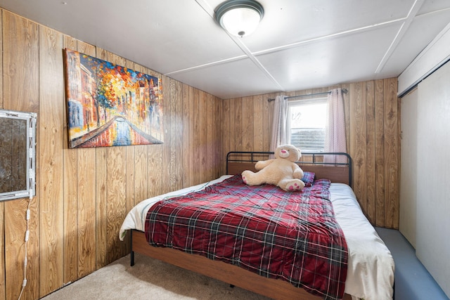 carpeted bedroom with wood walls