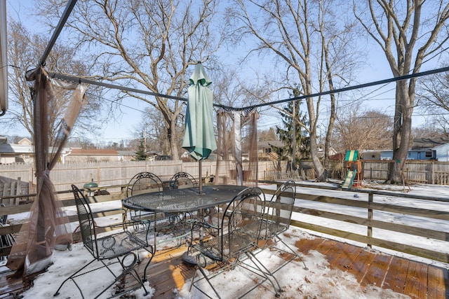 view of patio / terrace with outdoor dining space, a playground, and a fenced backyard