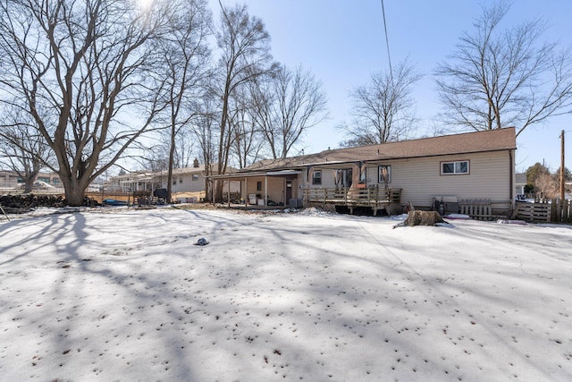 snow covered house featuring a deck