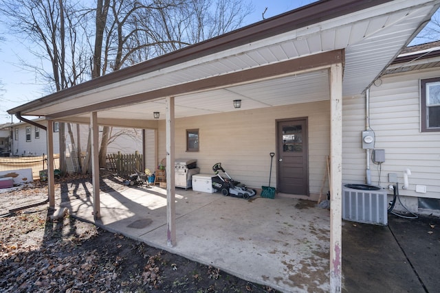 view of patio / terrace with a carport, fence, and central AC unit