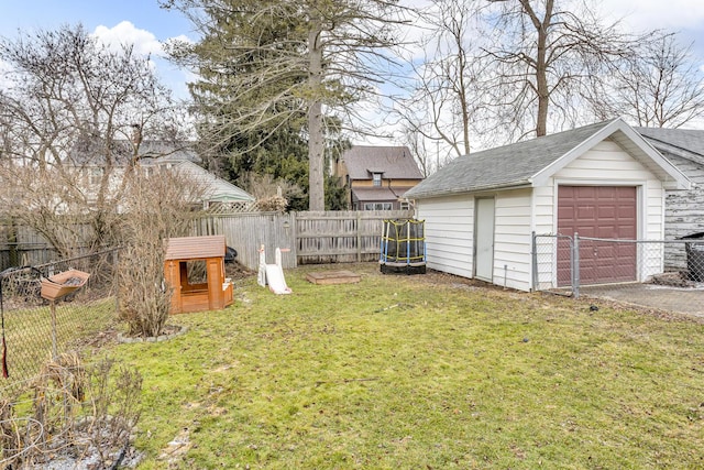 view of yard featuring an outbuilding, a detached garage, and fence