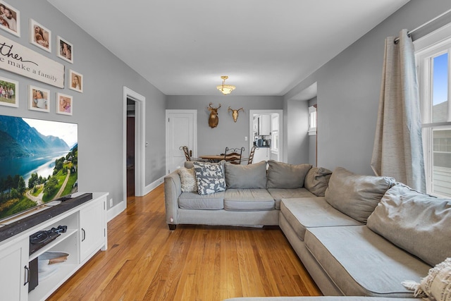 living area with light wood-style floors and baseboards