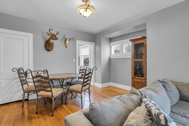 dining room featuring baseboards and light wood finished floors