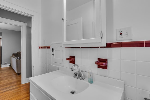 bathroom featuring tile walls, vanity, and wood finished floors